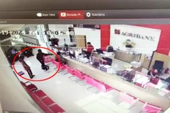 Hai tên cướp cầm súng xông vào ngân hàng.(Ảnh cắt từ camera an ninh)