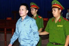 Cảnh sát dẫn giải bị cáo Đoàn Văn Vươn vào phòng xử án. Ảnh: Doãn Tấn - TTXVN