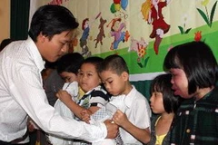 Tặng quà cho các thiếu nhi là nạn nhân chất độc da cam/dioxin tại Đà Nẵng. (Ảnh: TTXVN)