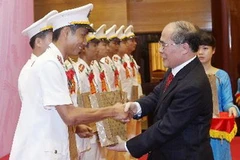 Chủ tịch Quốc hội Nguyễn Sinh Hùng tặng quà cho các thanh niên công an tiêu biểu. (Ảnh: Nhan Sáng/TTXVN)