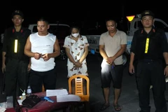 Lực lượng công an bắt các đối đối tượng trong đường dây mua, bán giấy tờ giả. (Ảnh: Tường Quang/TTXVN phát)
