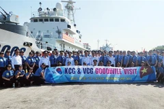 Các đại biểu chụp hình lưu niệm bên tàu CSB 8003. (Ảnh: TTXVN phát)