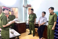 Bị can Nguyễn Văn Phương nghe đọc lệnh khám xét từ Cơ quan Cảnh sát điều tra, Công an tỉnh Cà Mau. (Ảnh: TTXVN phát)