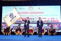 Trung tướng Lê Minh Hùng, Cục trưởng Cục Cảnh sát Quản lý trại giam, Chủ tịch Hội nghị APCCA 41 (bên phải) thực hiện nghi thức trao cờ APCCA cho đại diện Đoàn Hong Kong (Trung Quốc) - Chủ nhà Hội nghị APCCA lần thứ 42 năm 2024. (Ảnh: Phạm Kiên/TTXVN)