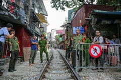 Sáng 10/10, tổ công tác liên ngành gồm công an quận Hoàn Kiếm, công an các phường có đường tàu chạy qua, cảnh sát giao thông đường sắt đã tiến hành phong toả các lối ra vào đoạn đường tàu phố Phùng Hưng, nơi các hộ kinh doanh càphê, nhà hàng. (Ảnh: Minh 