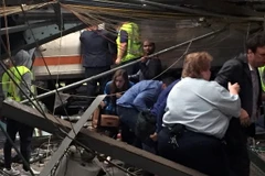 Lực lượng chức năng làm nhiệm vụ tại hiện trường vụ tai nạn ở Hoboken. (Nguồn: AFP/TTXVN)