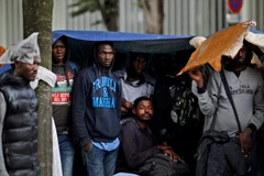 Người di cư chờ để chuyển tới trung tâm lưu trú mới sau khi cảnh sát tháo dỡ khu lán trại phía Bắc Paris. (Nguồn: EPA/TTXVN)