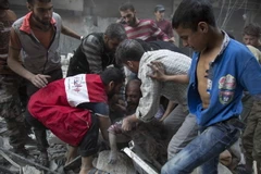 Một người đàn ông đau khổ sau khi tìm thấy xác con dưới những đống đổ nát sau các vụ không kích tại Aleppo ngày 27/9. (Nguồn: AFP/TTXVN)