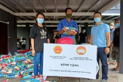 Đại diện Đại sứ quán Việt Nam trao quà cho đồng bào người Chăm Việt Nam tại Perak, Malaysia.(Ảnh: TTXVN)