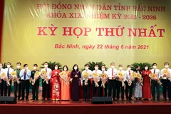 Lãnh đạo tỉnh Bắc Ninh tặng hoa các đồng chí được bầu giữ các chức danh chủ chốt của UBND tỉnh khóa XIX. (Ảnh: Đinh Văn Nhiều/TTXVN)