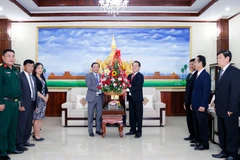 Đại sứ Việt Nam tại Lào Nguyễn Bá Hùng trao lẵnh hoa chúc mừng 66 năm Ngày thành lập Đảng NDCM Lào. (Ảnh: Phạm Kiên/TTXVN)