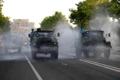 Lực lượng chức năng tiến hành phun khử khuẩn. (Ảnh: Văn Tý/TTXVN)