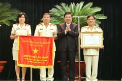 Thay mặt lãnh đạo Đảng và Nhà nước, Chủ tịch UBND Thành phố Hồ Chí Minh Nguyễn Thành Phong trao danh hiệu Anh hùng Lao động thời kỳ đổi mới cho Viện Kiểm sát nhân dân Thành phố Hồ Chí Minh. (Ảnh: Thành Chung/TTXVN)