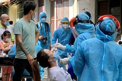 Tiến hành lấy mẫu xét nghiệm virus COVID-19 cho người dân. (Ảnh: Hồng Giang/TTXVN)