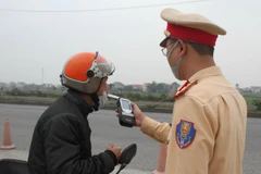 Cảnh sát giao thông kiểm tra nồng độ cồn của người điều khiển phương tiện. (Ảnh: Thùy Dung/TTXVN)