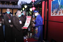 Các chư tăng tham quan, xin chữ ông đồ tại lễ hội Phố ông Đồ 'Xuân bình an.' (Ảnh: Xuân Khu/TTXVN)