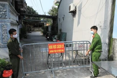 Lực lượng chức năng phong tỏa ngõ 83 đường Dục Nội (Đông Anh, Hà Nội) nơi ở của ca bệnh 2911. (Ảnh: Minh Đức/TTXVN)