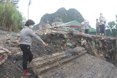 Người dân khu Diêm Thủy (phường Cẩm Đông, Tp Cẩm Phả) bức xúc do công trình thi công chặn dòng khiến nước dâng làm sạt lở kè . (Ảnh: Thanh Vân/TTXVN)