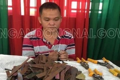 Đối tượng Phạm Bá Quang cùng tang vật. (Ảnh: TTXVN phát)