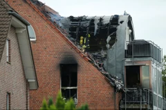 Máy bay đâm vào khiến mái tòa chung cư bốc cháy. (Nguồn: AP)