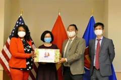 Tham tán Công sứ Hoàng Thị Thanh Nga trao tặng khẩu trang cho đại diện chính quyền Thủ đô Washington. (Ảnh: PV TTXVN tại Mỹ)