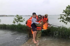 Công an huyện Thạch Hà (Hà Tĩnh) hỗ trợ nhân dân sơ tán đến nơi an toàn. (Ảnh: TTXVN phát)