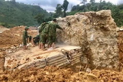 Lực lượng công binh phá khối bê tông cốt thép lớn tại vị trí sạt lở vui lấp các công nhân. (Ảnh: TTXVN phát)