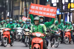 Các tài xế Grab với những băng rôn khẩu hiệu "Grab thu thuế VAT bất hợp lý". (Ảnh: Thành Đạt/TTXVN)