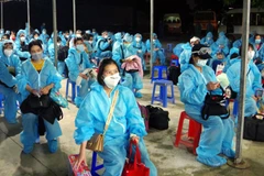 Làm thủ tục cách ly tập trung đối với các công dân Việt Nam từ nước ngoài về nước. (Ảnh: Trung Hiếu/TTXVN)