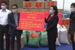 Lãnh đạo Thành ủy Hà Nội tặng quà cho huyện Mê Linh để phòng, chống dịch COVID-19. (Ảnh TTXVN phát)