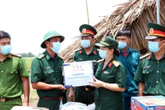 Đại diện Ban Phụ nữ Quân khu 7 trao tặng quà cho Chốt kiểm dịch biên giới số 7 Mộc Bài, huyện Bến Cầu, tỉnh Tây Ninh. (Ảnh: Xuân Khu/TTXVN)