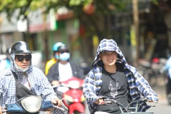 hời tiết nắng nóng, tia UV ở mức cao, người dân cần trang bị tốt đồ bảo hộ khi ra đường để bảo vệ sức khỏe. (Ảnh: Thanh Tùng/TTXVN)
