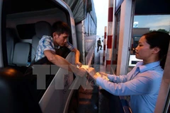 Lái xe trả tiền mua vé tại trạm thu phí BOT số 1, Quốc lộ 5 huyện Văn Lâm. (Ảnh: Phạm Kiên/TTXVN)