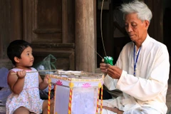 Nghệ nhân làm đèn kéo quân. (Ảnh minh họa: TTXVN)