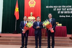 Bí thư tỉnh ủy Quảng Bình, Vũ Đại Thắng tặng hoa chức mừng ông Trần Thắng (phải) được bầu làm Chủ tịch UBND tỉnh Quảng Bình, ông Trần Hải Châu (trái) được bầu làm Chủ tịch HĐND tỉnh Quảng Bình khóa XVII, nhiệm kỳ 2016-2021. (Ảnh: TTXVN phát)