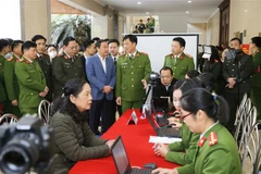 Thiếu tướng Nguyễn Duy Ngọc, Thứ trưởng Bộ Công an và các đại biểu thăm quan việc triển khai của các đơn vị công an quận cấp Căn cước công dân lưu động. (Ảnh: Doãn Tấn/TTXVN)