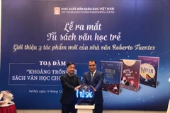 Tổng Giám đốc Nhà xuất bản Giáo dục Việt Nam Hoàng Lê Bách và Đại sứ Cộng hòa Chile Jaime Chomali Garib thực hiện nghi thức ra mắt Tủ sách văn học trẻ và ba tác phẩm văn học của nhà văn Chile Roberto Fuentes. (Ảnh: Phương Lan/Vietnam+)