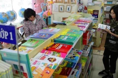Phụ huynh lựa chọn sách giáo khoa. (Ảnh: TTXVN)