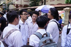 Thí sinh vui vẻ trao đổi sau khi làm xong bài thi môn Ngoại ngữ. (Ảnh: Hoàng Hiếu/Vietnam+)