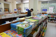 Phụ huynh lựa chọn sách giáo khoa. (Ảnh: TTXVN)