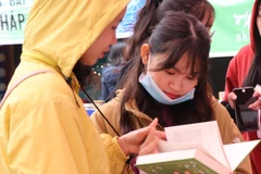 Dù trời mưa rét nhưng vẫn khá đông bạn trẻ đến tham gia chương trình để đổi và chọn mua sách. (Ảnh: PV/Vietnam+)