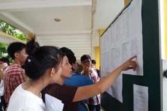 Thí sinh, phụ huynh tìm hiểu thông tin để làm hồ sơ xét tuyển đại học. (Ảnh: Phạm Mai/Vietnam+)
