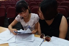 Thí sinh, phụ huynh tìm hiểu thông tin về thủ tục nhập học. (Ảnh: Phạm Mai/Vietnam+)