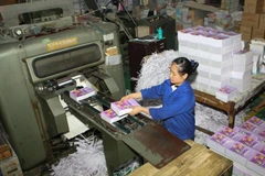 Hoàn thiện ấn phẩm sách giáo khoa trước khi bán ra thị trường. (Ảnh: TTXVN)