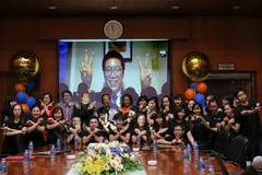 Sinh viên Phan Lê Thanh Chương, đang sinh sống và làm việc tại Mỹ, chụp ảnh cùng sinh viên, cán bộ Đại học Trực tuyến FUNiX trong Lễ Trao bằng tốt nghiệp của mình. (Ảnh: PV/Vietnam+)