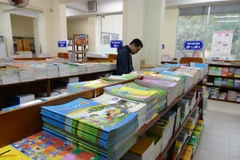 Phụ huynh lựa chọn sách giáo khoa. (Ảnh: TTXVN)