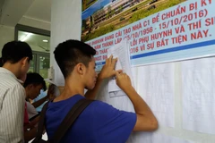 Thí sinh tìm hiểu thông tin và điền hồ sơ xét tuyển đại học. (Ảnh: Phạm Mai/Vietnam+)