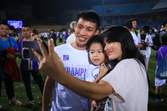 Tiền vệ Đỗ Hùng Dũng ăn mừng chức vô địch V-League 2022 bên gia đình nhỏ. (Ảnh: PV/Vietnam+) 