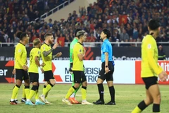 Cầu thủ Malaysia phân trần với trọng tài về tình huống phạm lỗi với Đoàn Văn Hậu. (Ảnh: PV/Vietnam+) 