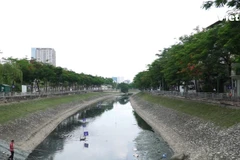 Tuy trên sông Tô Lịch vẫn còn có váng đen nhưng không còn mùi hôi thối nữa. Người dân thậm chí còn có thể câu cá trên đoạn sông này. (Ảnh: PV/Vietnam+)